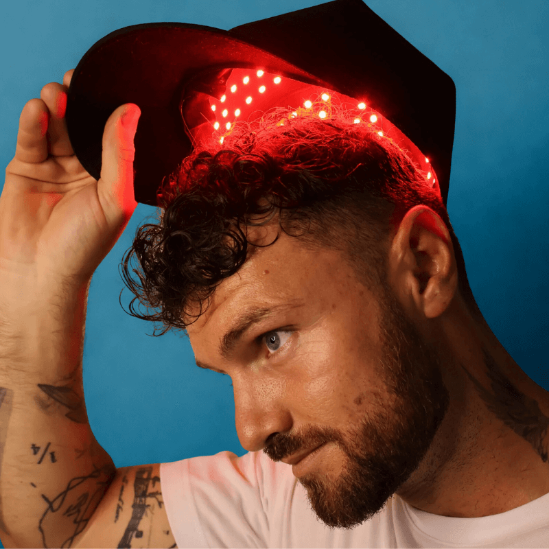 Man wearing a hat with red LED lights against a blue background
